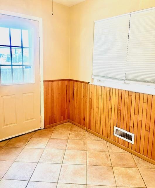 interior space featuring wood walls and light tile patterned flooring