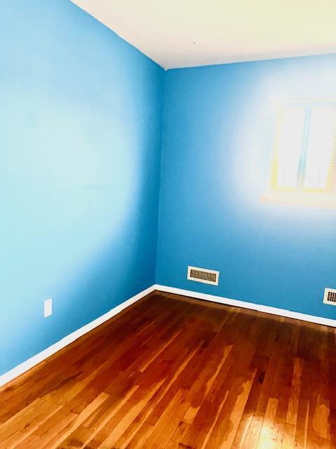 unfurnished room with wood-type flooring