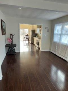 unfurnished living room with dark hardwood / wood-style flooring