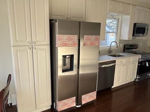 kitchen featuring stainless steel appliances, dark hardwood / wood-style flooring, sink, and white cabinets