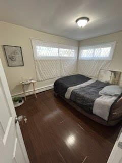 bedroom with dark wood-type flooring