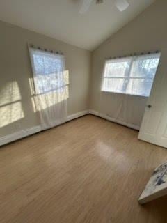 interior space with lofted ceiling, ceiling fan, and light wood-type flooring