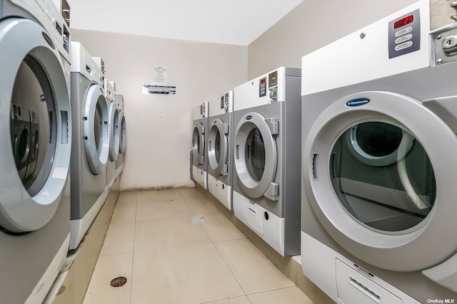 laundry room with washer and clothes dryer and light tile patterned flooring