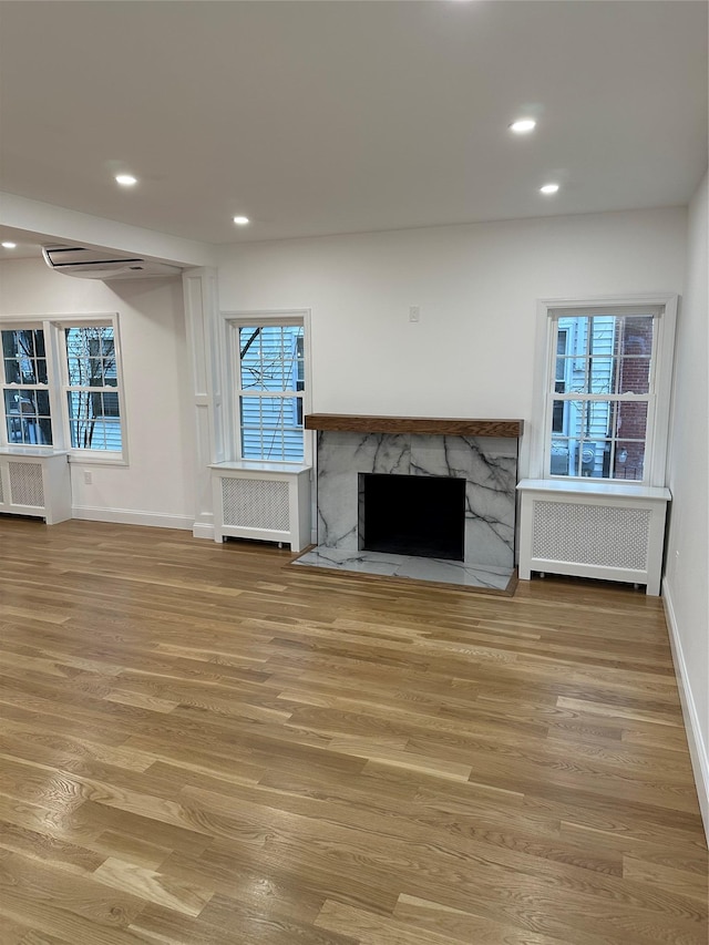 unfurnished living room featuring light hardwood / wood-style floors and radiator heating unit