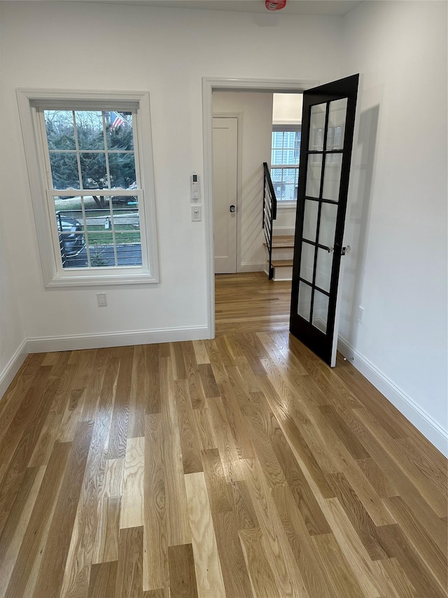 spare room with plenty of natural light, light wood-type flooring, and french doors