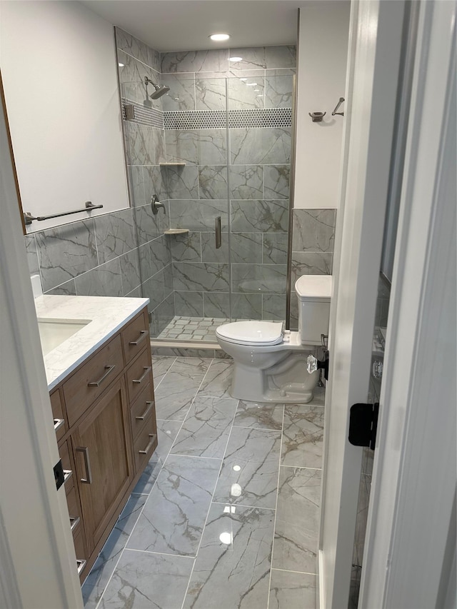 bathroom featuring vanity, an enclosed shower, tile walls, and toilet