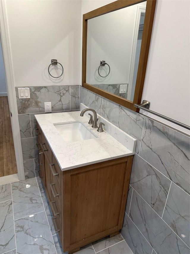 bathroom featuring vanity and tile walls