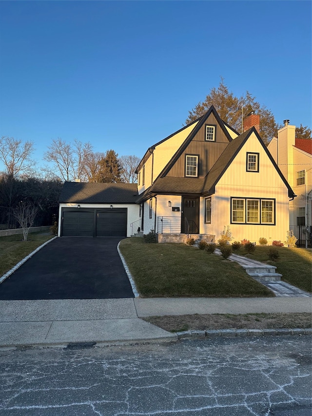 view of front of property featuring a garage, driveway, and a front yard