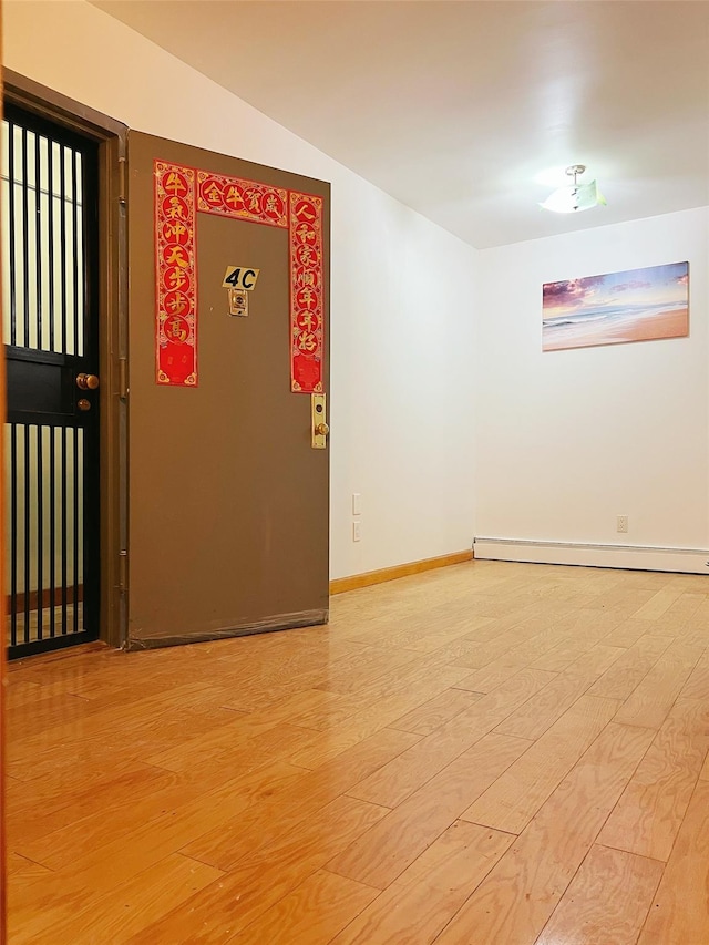 spare room featuring hardwood / wood-style floors and a baseboard radiator