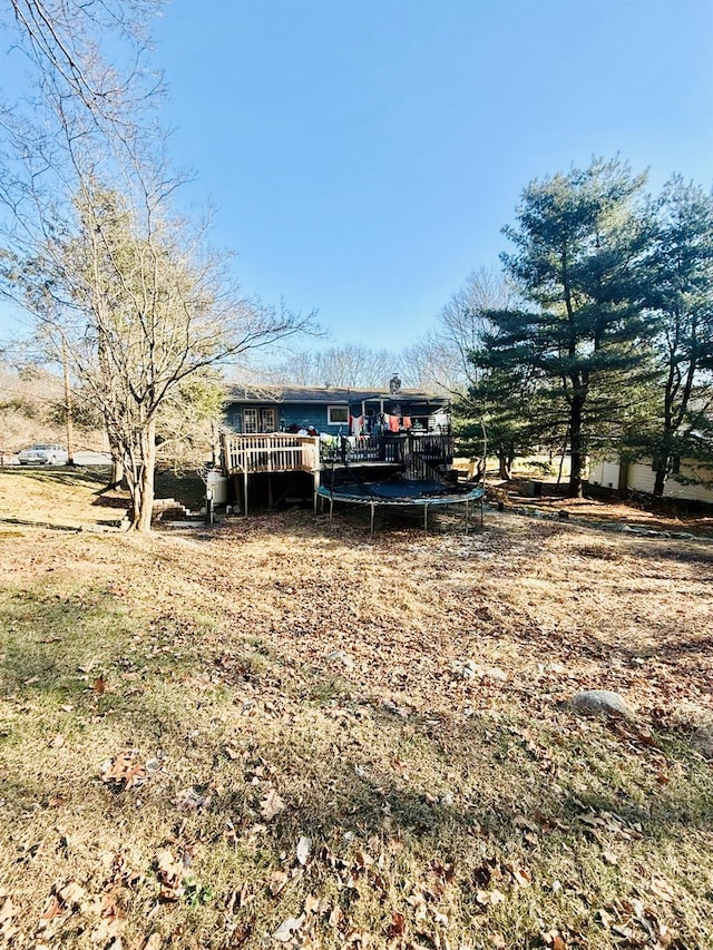 view of yard featuring a deck and a trampoline