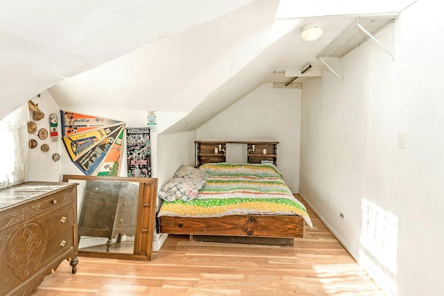 bedroom featuring vaulted ceiling and light hardwood / wood-style flooring