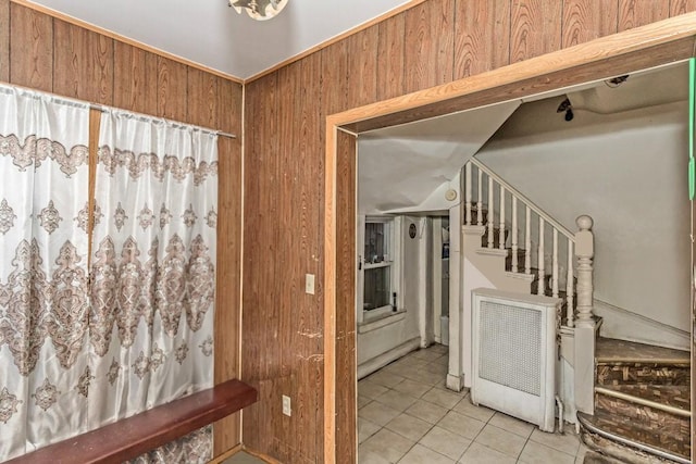 interior space with light tile patterned floors and wooden walls