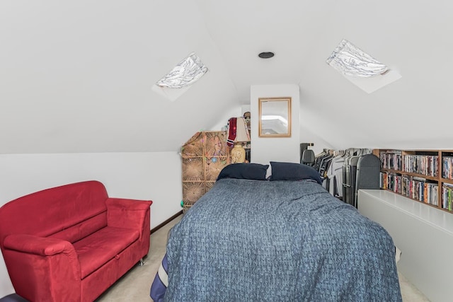 carpeted bedroom featuring lofted ceiling with skylight