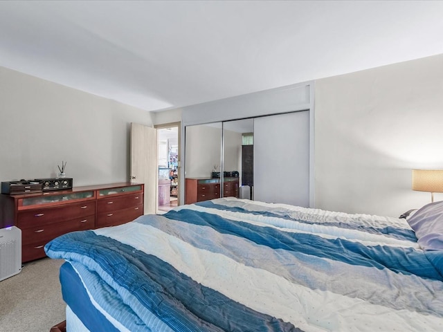 bedroom with light colored carpet and a closet