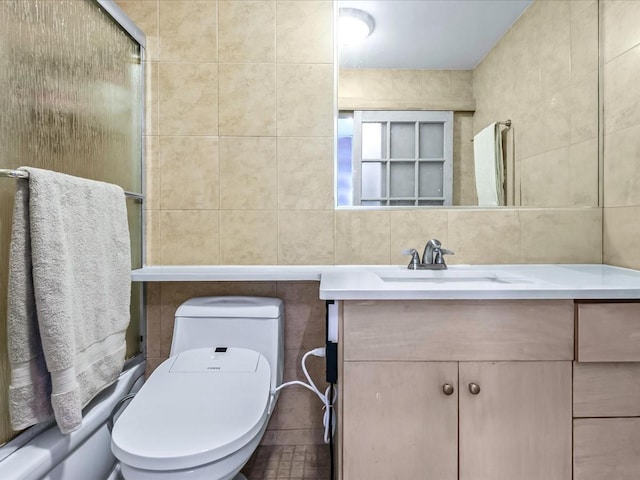 bathroom featuring vanity, toilet, tile walls, tasteful backsplash, and a shower with shower door