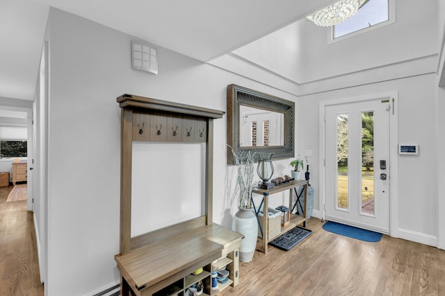 foyer with hardwood / wood-style flooring and an inviting chandelier