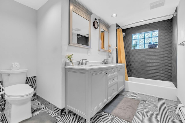 full bathroom featuring vanity, tiled shower / bath combo, and toilet