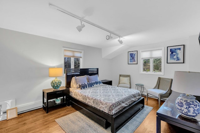 bedroom with hardwood / wood-style floors and rail lighting