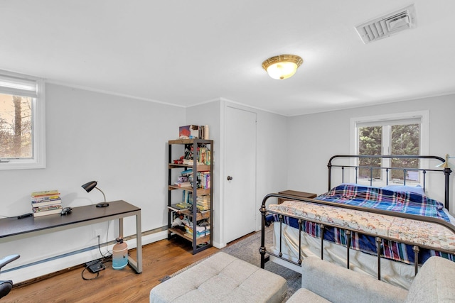 bedroom featuring wood-type flooring and a baseboard radiator