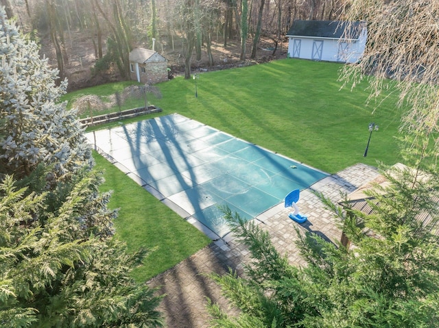 view of swimming pool with a yard and a shed