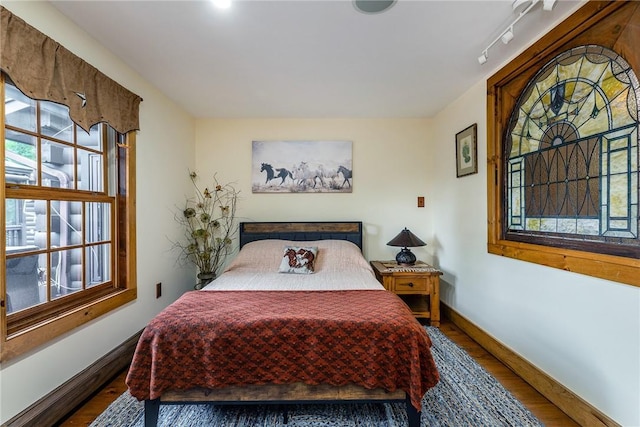 bedroom featuring dark wood-type flooring and rail lighting