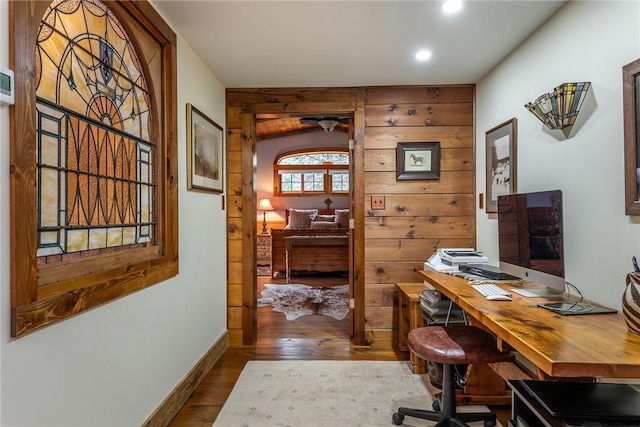 home office with hardwood / wood-style floors and wooden walls