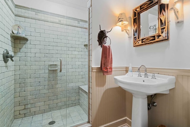 bathroom featuring a shower with shower door and wooden walls