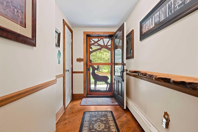 doorway to outside featuring hardwood / wood-style floors and baseboard heating