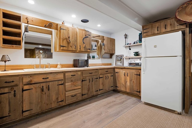 kitchen featuring sink, light wood-type flooring, and white fridge