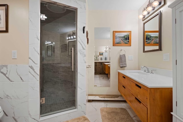 bathroom with a shower with shower door and vanity