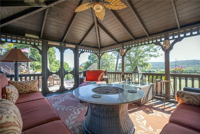 exterior space featuring ceiling fan and lofted ceiling with beams