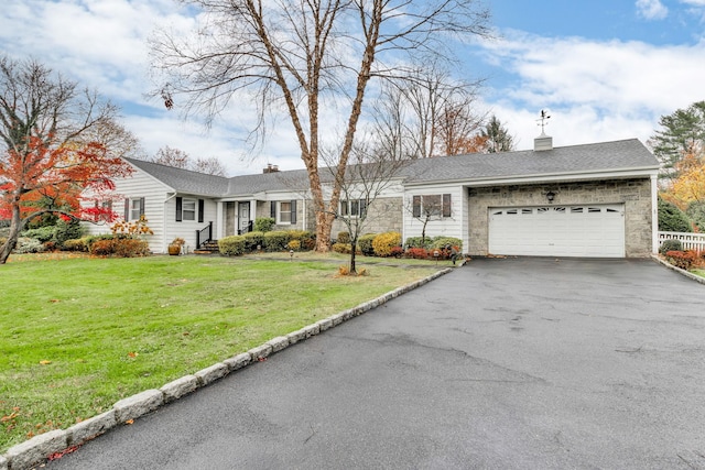 ranch-style house featuring a garage and a front lawn