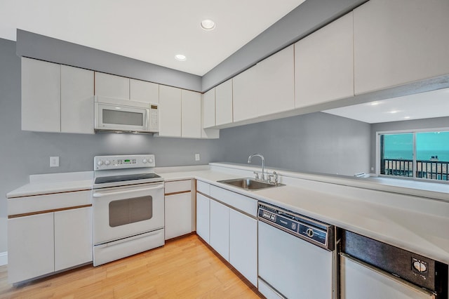 kitchen featuring white cabinetry, sink, white appliances, and light hardwood / wood-style flooring