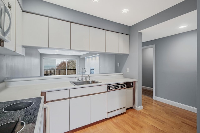 kitchen featuring white appliances, light hardwood / wood-style flooring, white cabinetry, and sink