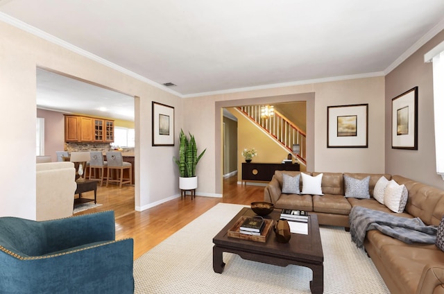 living room with ornamental molding and light hardwood / wood-style flooring