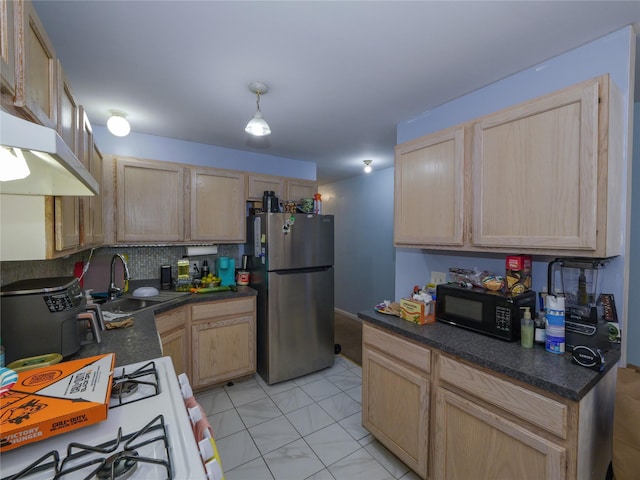 kitchen with white gas stove, sink, tasteful backsplash, stainless steel fridge, and light brown cabinetry