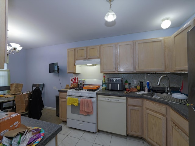 kitchen featuring sink, hanging light fixtures, white appliances, and an inviting chandelier