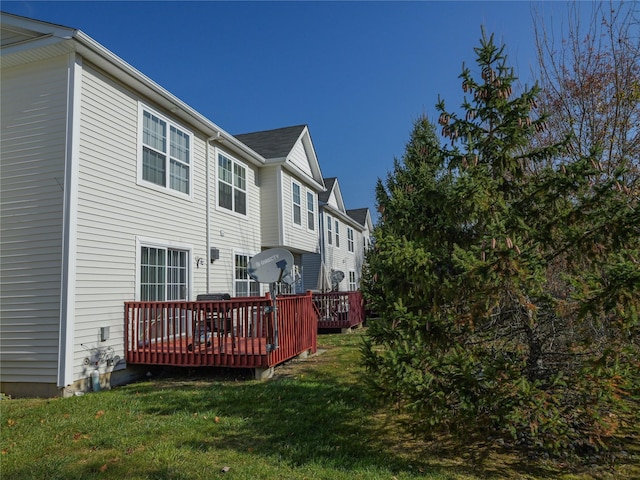 rear view of house featuring a yard and a deck