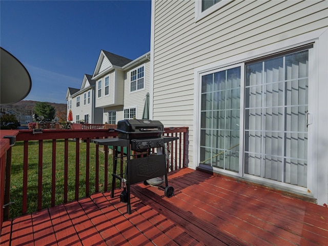 wooden deck with a yard and grilling area