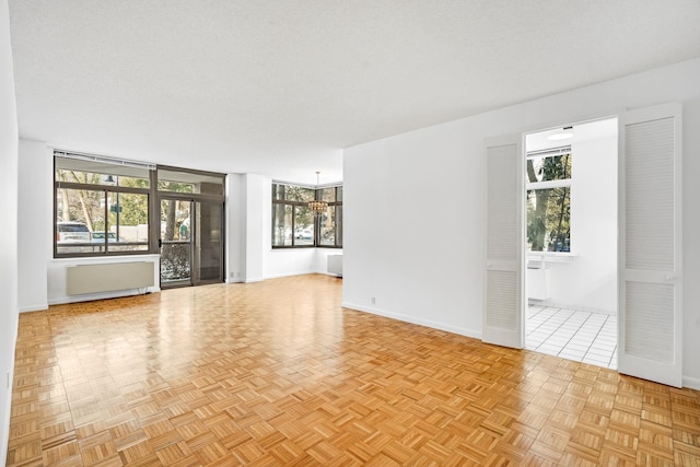 unfurnished room with a textured ceiling and light parquet flooring