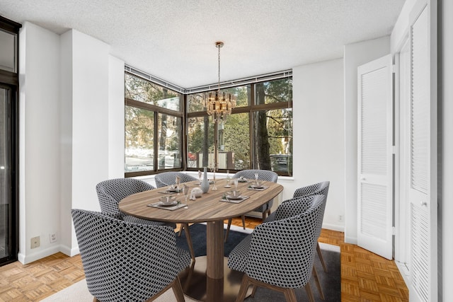 dining space with light parquet floors, a textured ceiling, and a wealth of natural light