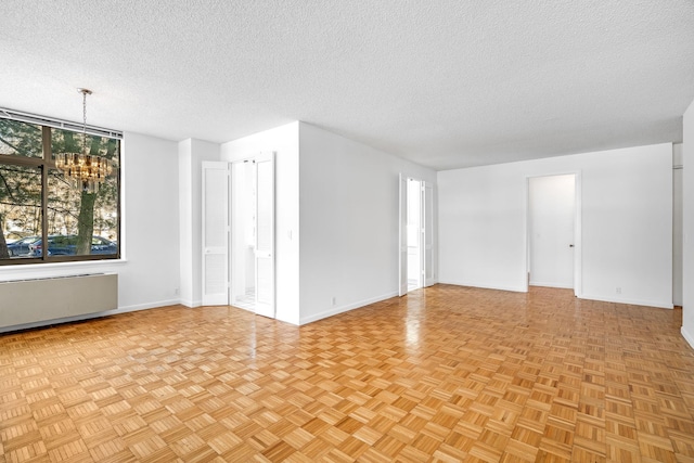 spare room with an inviting chandelier and a textured ceiling