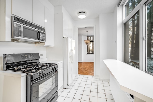 kitchen with white cabinetry, light tile patterned floors, black appliances, and a chandelier