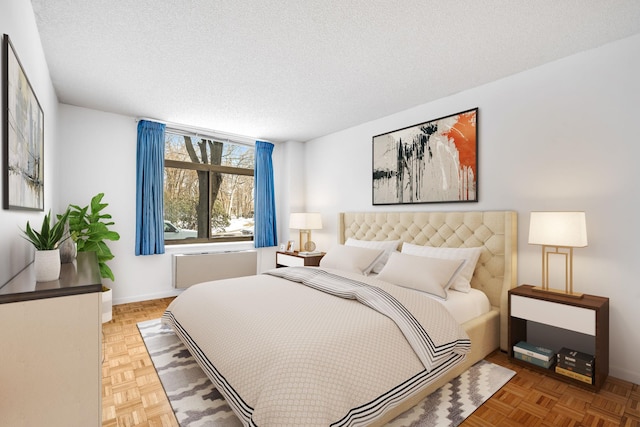 bedroom with parquet floors and a textured ceiling