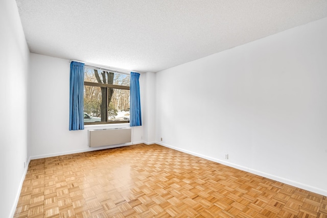 spare room featuring a textured ceiling and radiator