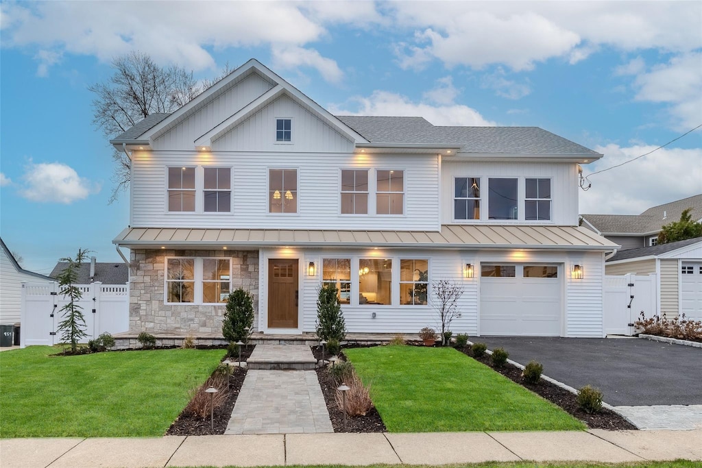 modern inspired farmhouse with a garage and a front lawn