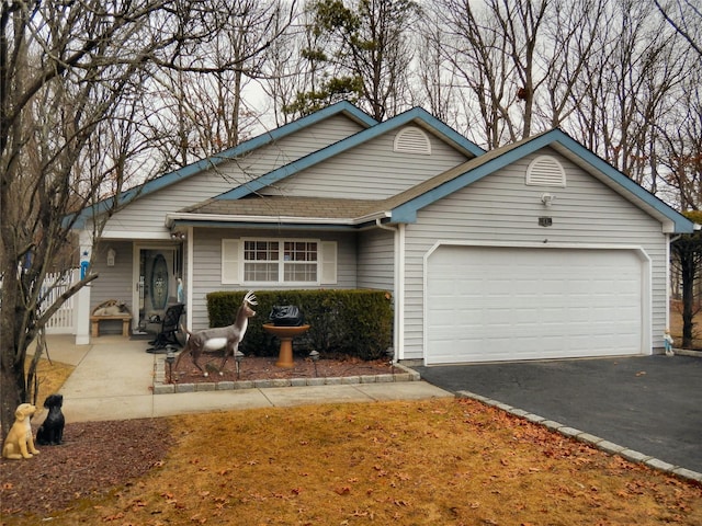 view of front of home with driveway, roof with shingles, and an attached garage