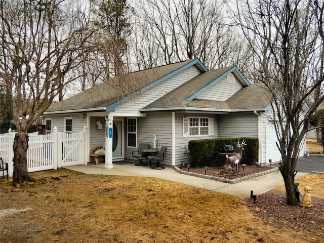 view of front of house featuring roof with shingles and fence