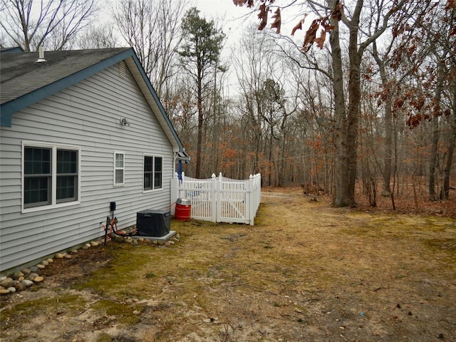 view of side of property with cooling unit and fence