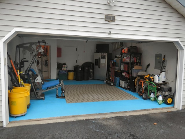 garage with electric panel and washer and dryer